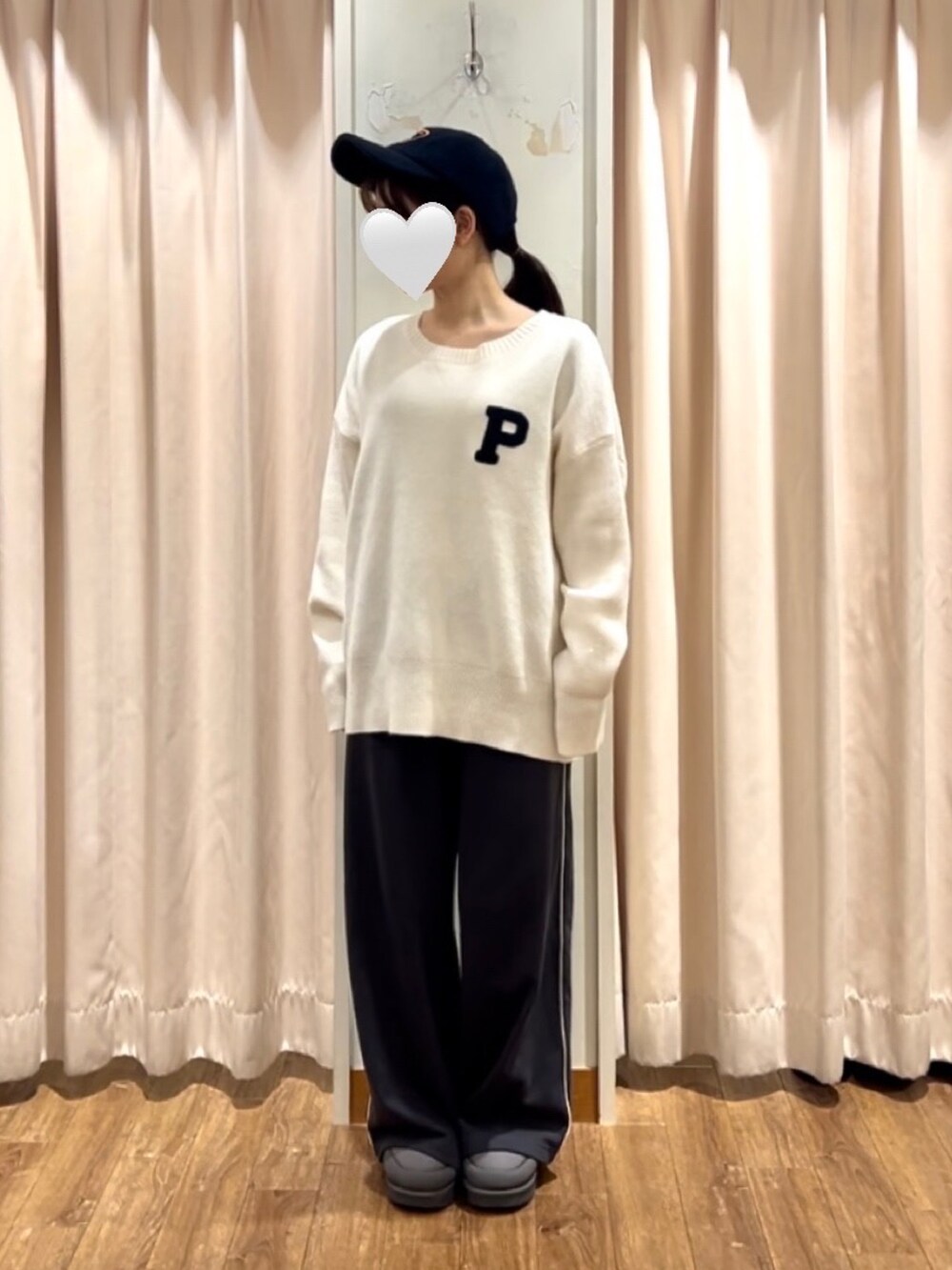 ホワイト系のニット/セーター、グレー系のドレスシューズ、ブルー系のハットを着用したレディースの秋コーディネートの2枚目の写真