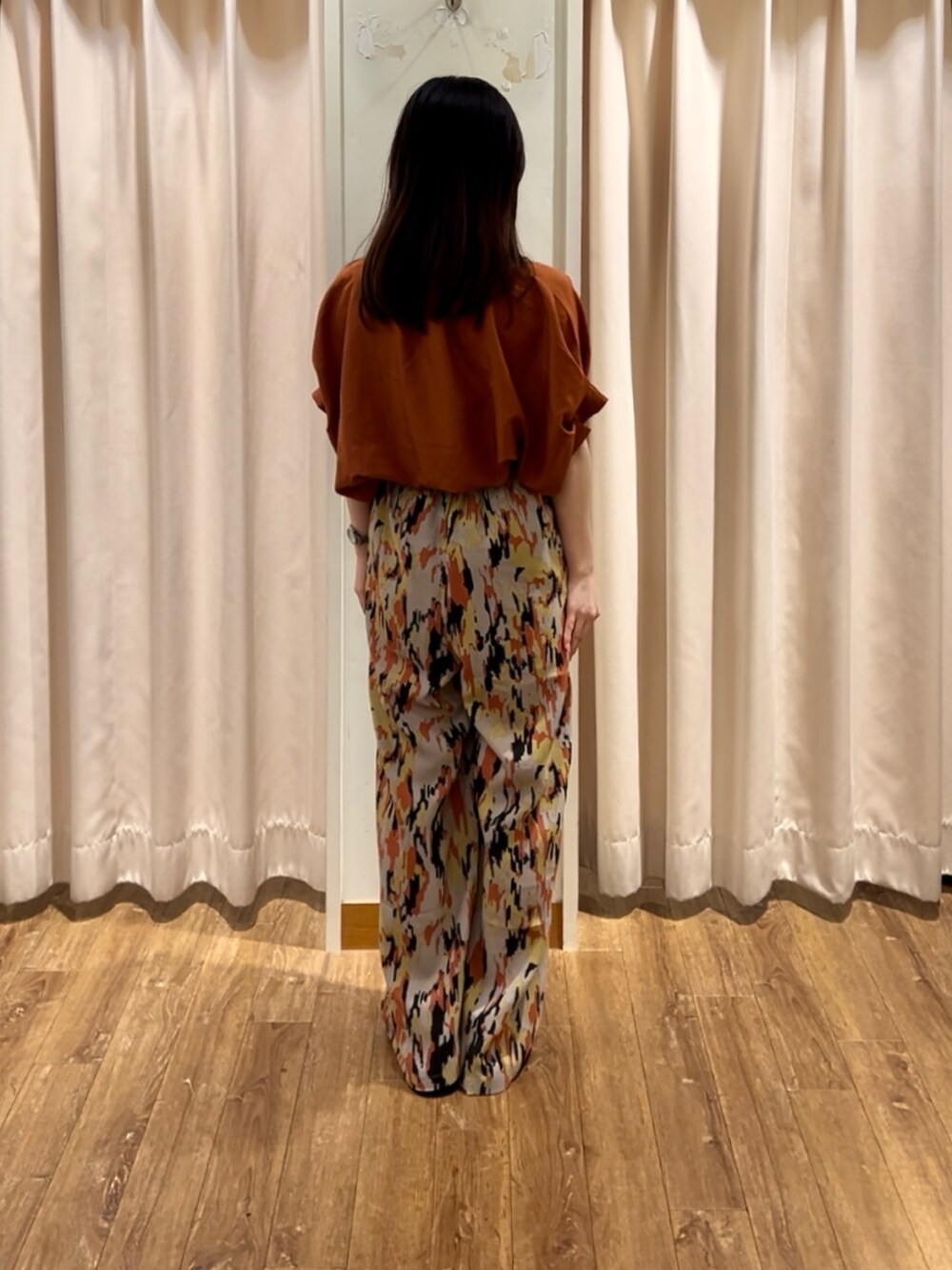 ベージュ系のその他パンツ、レッド系のシャツ/ブラウス、ホワイト系のドレスシューズを着用したレディースの夏コーディネートの2枚目の写真