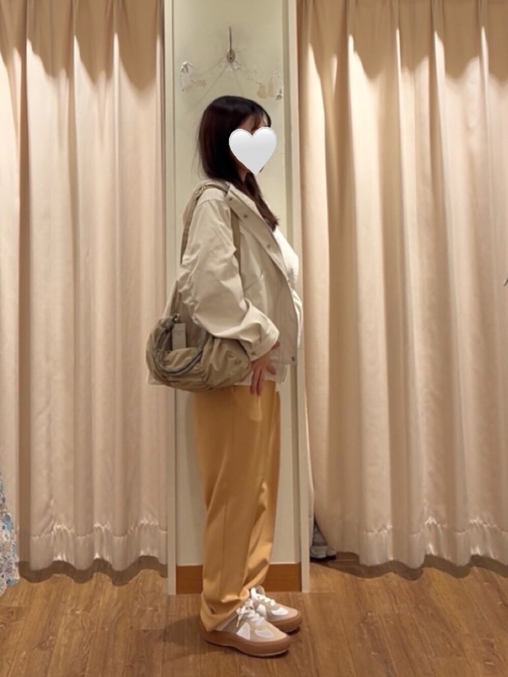 ホワイト系のブルゾン、オレンジ系のその他パンツ、ホワイト系のドレスシューズを着用したレディースの冬コーディネートの2枚目の写真