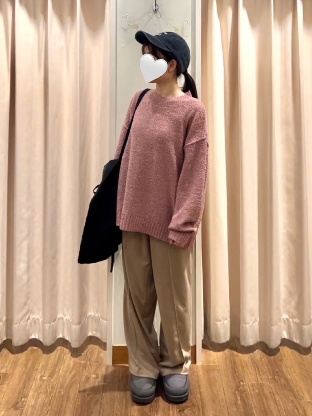 グレー系のドレスシューズ、ブラック系のハンドバッグ、ピンク系のニット/セーターを着用したレディースの秋コーディネートの2枚目の写真