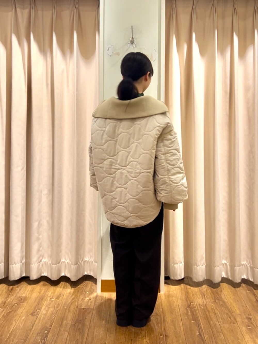 グリーン系のニット/セーター、ホワイト系のノーカラージャケット、ブラウン系のその他パンツを着用したレディースの秋コーディネートの3枚目の写真