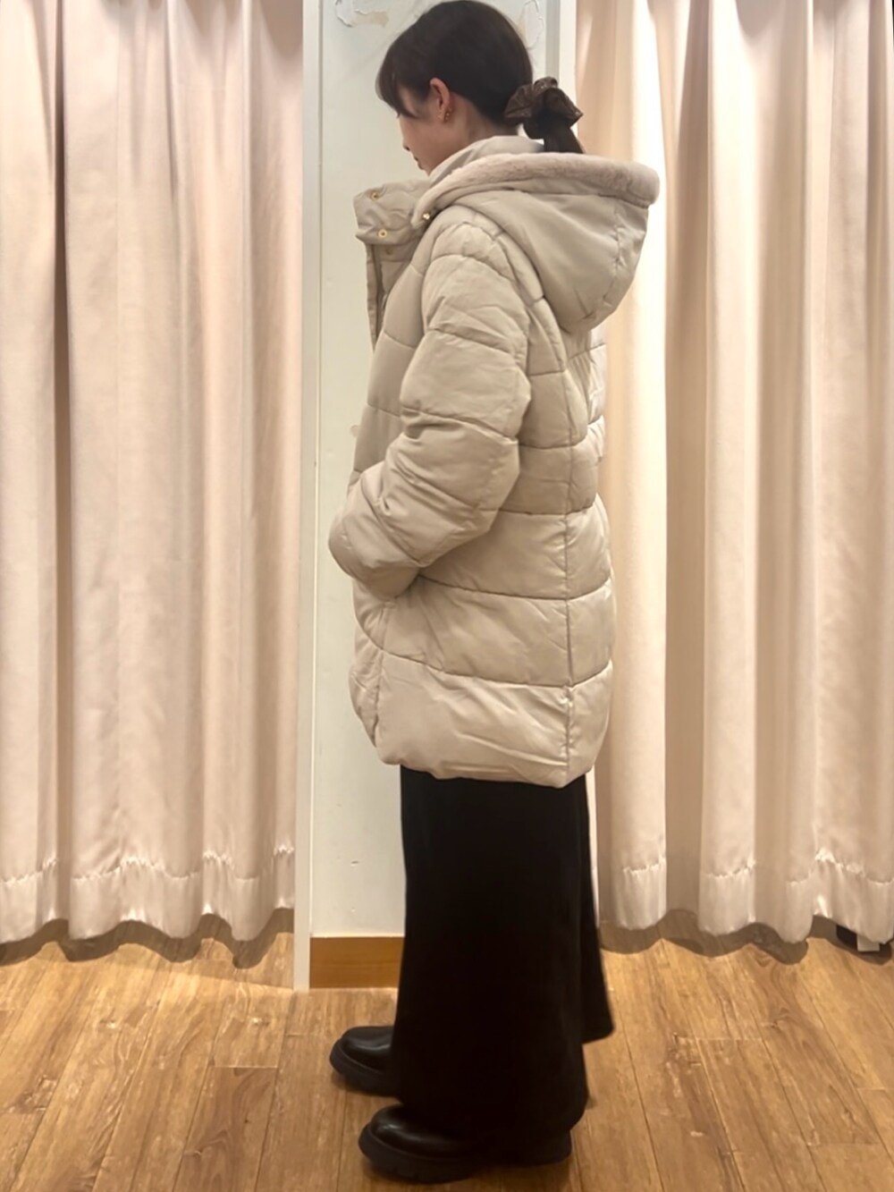 ベージュ系のニット/セーター、ブラック系のブーツ、ベージュ系のその他アウターを着用したレディースの秋コーディネートの2枚目の写真