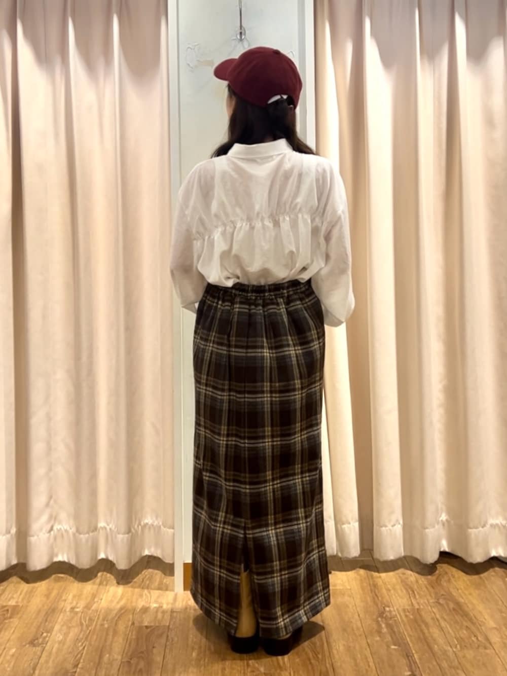 ブラウン系のスカート、ベージュ系のブーツ、ホワイト系のシャツ/ブラウスを着用したレディースの秋コーディネートの3枚目の写真