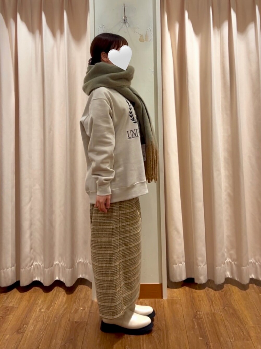 イエロー系のスカート、ベージュ系のTシャツ/カットソー、ベージュ系のブーツを着用したレディースの冬コーディネートの2枚目の写真