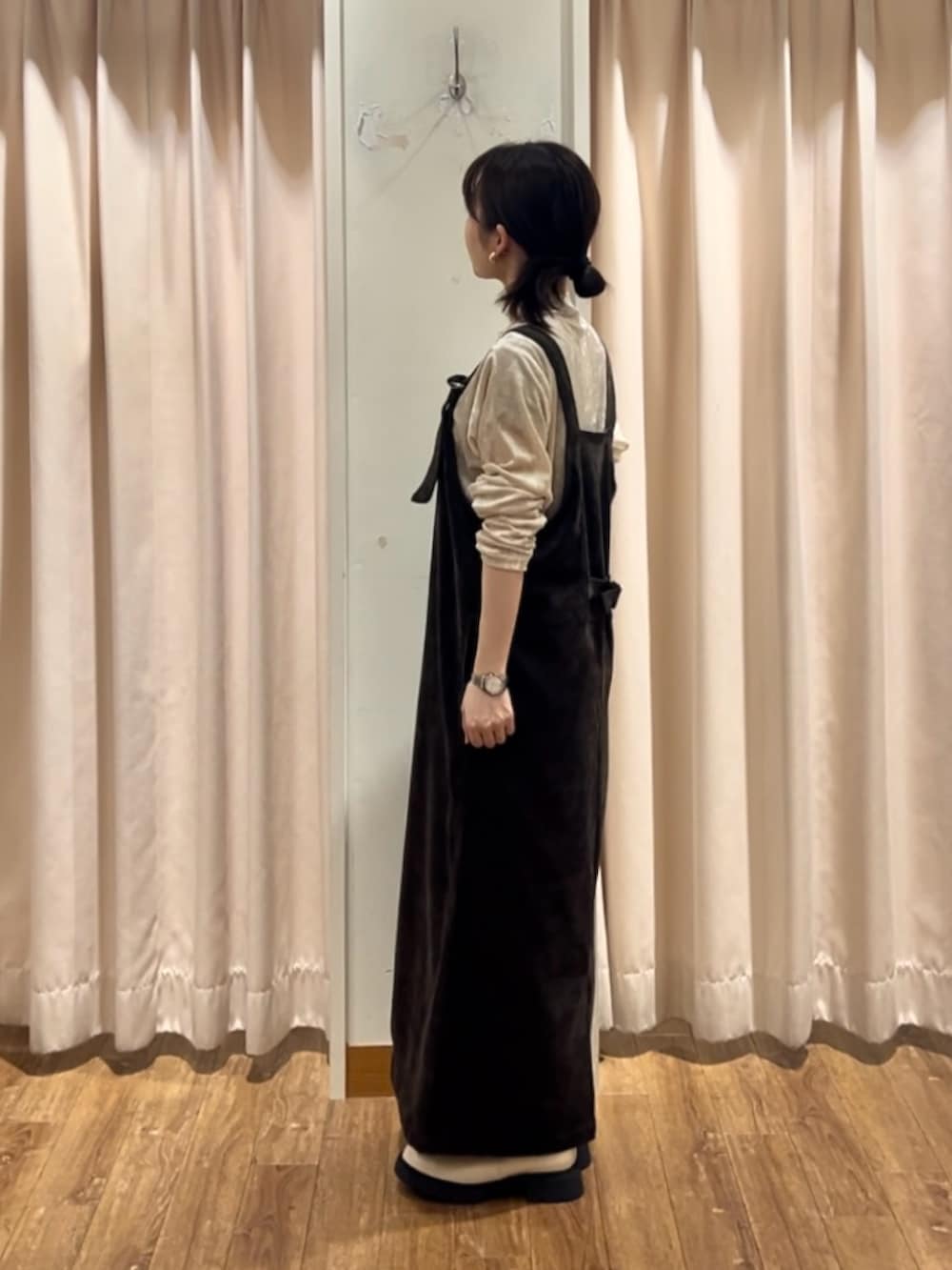 ブラウン系のワンピース、ホワイト系のTシャツ/カットソー、ベージュ系のブーツを着用したレディースの秋コーディネートの2枚目の写真