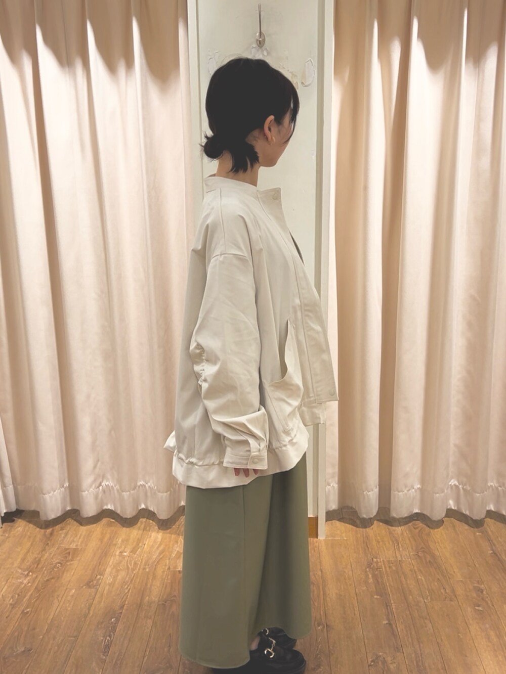 ホワイト系のブルゾン、グリーン系のワンピース、グレー系のTシャツ/カットソーを着用したレディースの春コーディネートの2枚目の写真