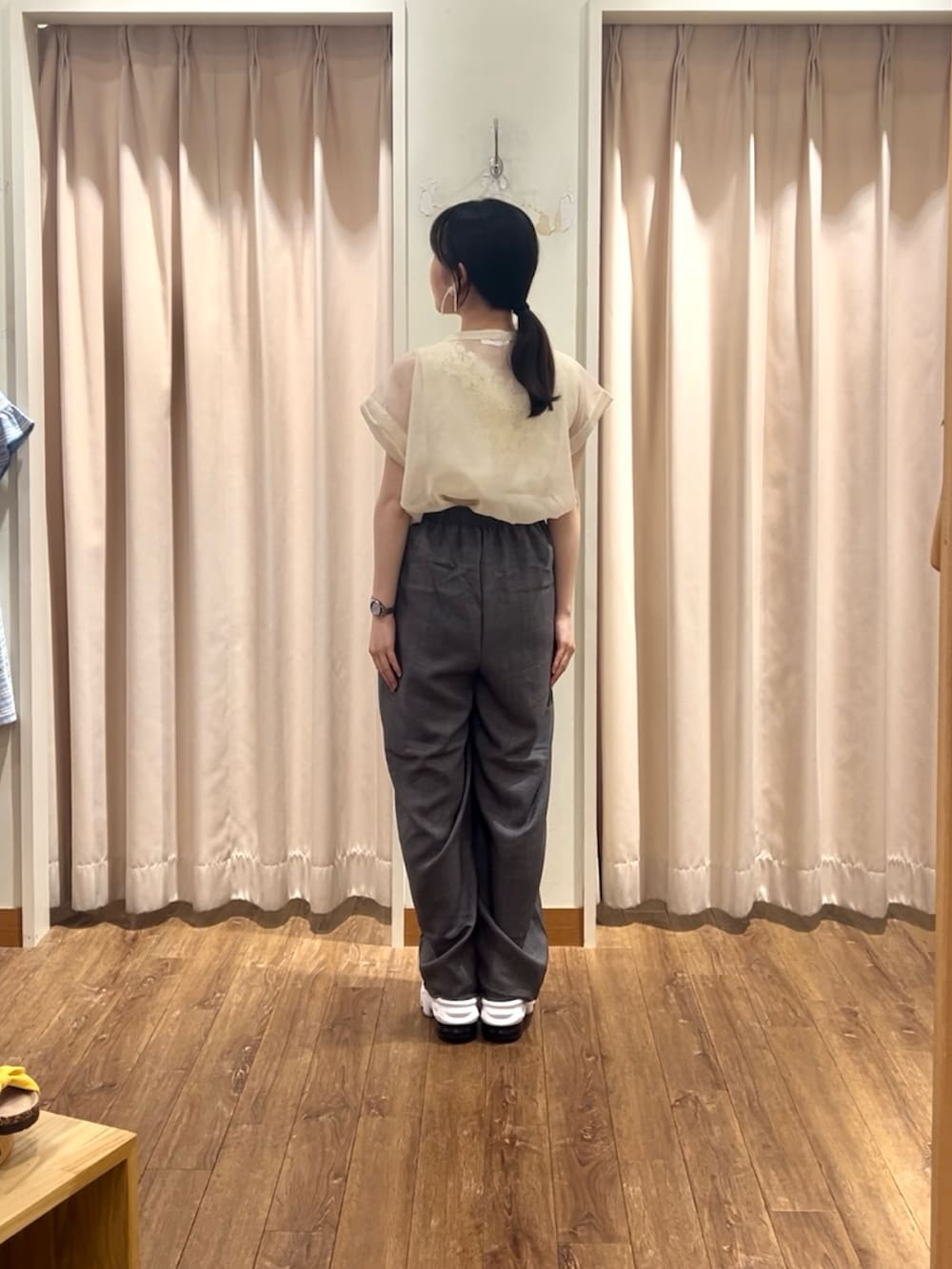 ホワイト系のシャツ/ブラウス、グレー系のパンツ、ベージュ系のタンクトップを着用したレディースの夏コーディネートの2枚目の写真