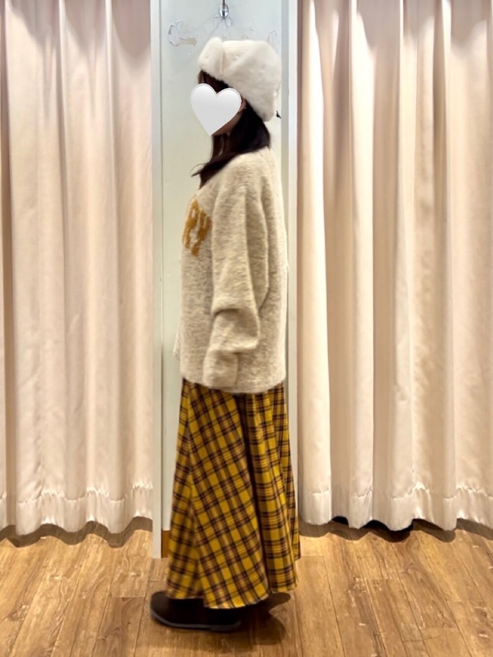 ベージュ系のニット/セーター、イエロー系のスカート、ブラウン系のドレスシューズを着用したレディースの秋コーディネートの2枚目の写真