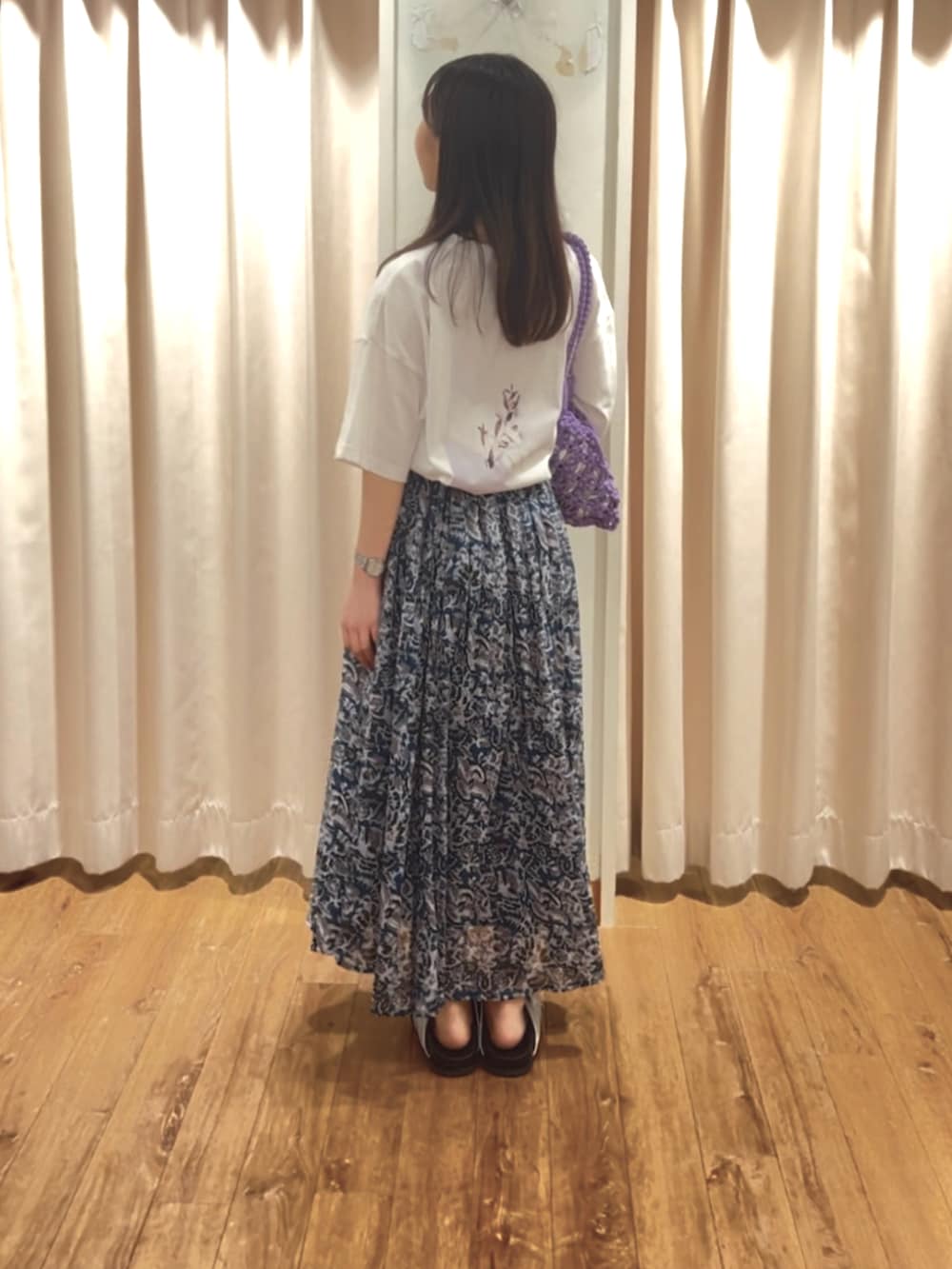 ホワイト系のTシャツ/カットソー、ブルー系のスカート、パープル系のハンドバッグを着用したレディースの夏コーディネートの2枚目の写真