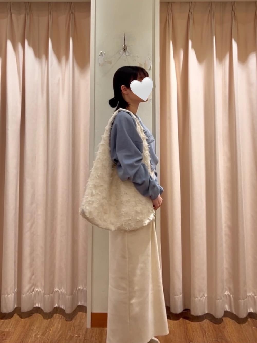 ホワイト系のハンドバッグ、ホワイト系のスカート、ベージュ系のスニーカーを着用したレディースの冬コーディネートの2枚目の写真