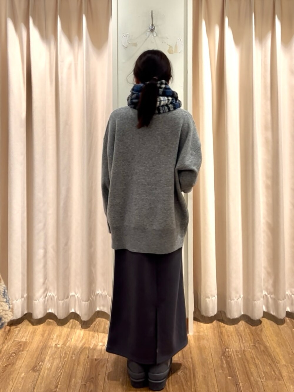 グレー系のドレスシューズ、グレー系のスカート、グレー系のニット/セーターを着用したレディースの秋コーディネートの3枚目の写真