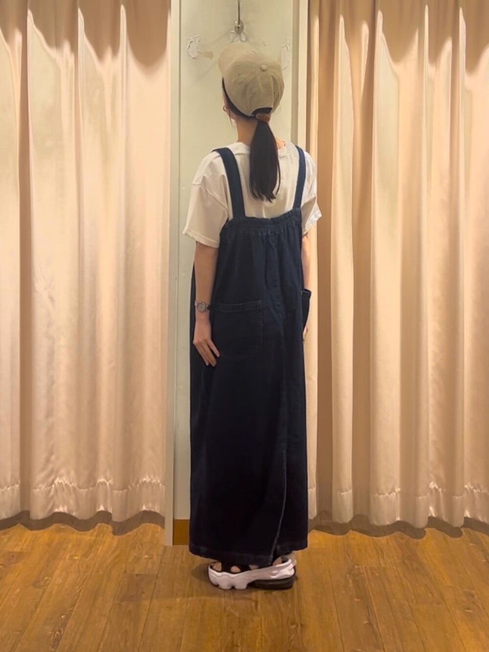 ブルー系のワンピース、ホワイト系のTシャツ/カットソー、ベージュ系のハットを着用したレディースの秋コーディネートの2枚目の写真
