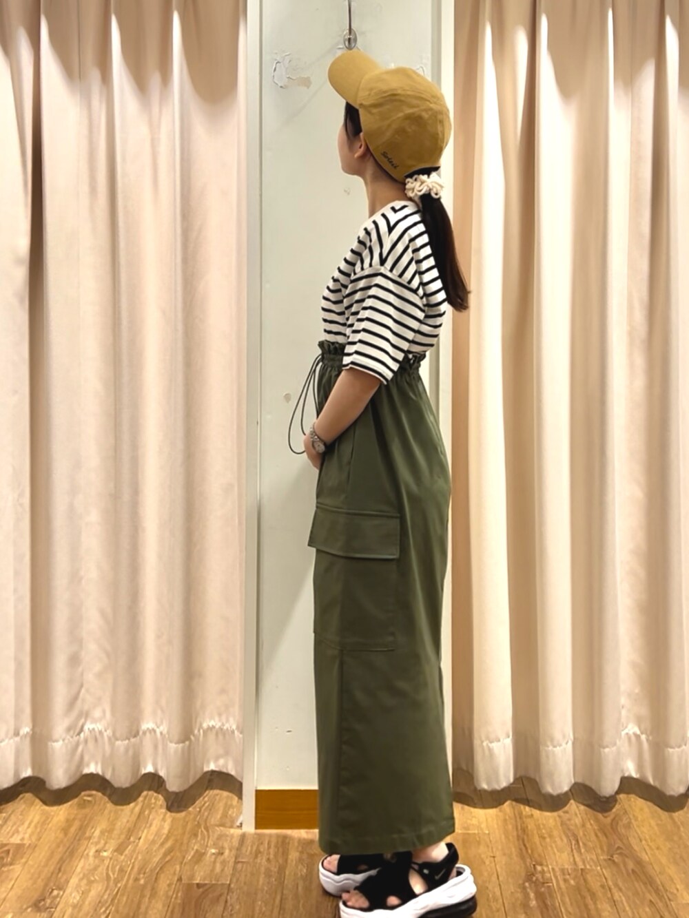 グリーン系のスカート、ホワイト系のTシャツ/カットソーを着用したレディースの夏コーディネートの2枚目の写真