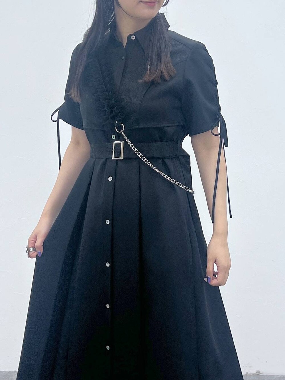 ブラック系のスニーカー、ブラック系のワンピース、シルバー系のスマホグッズを着用したレディースの夏コーディネートの4枚目の写真