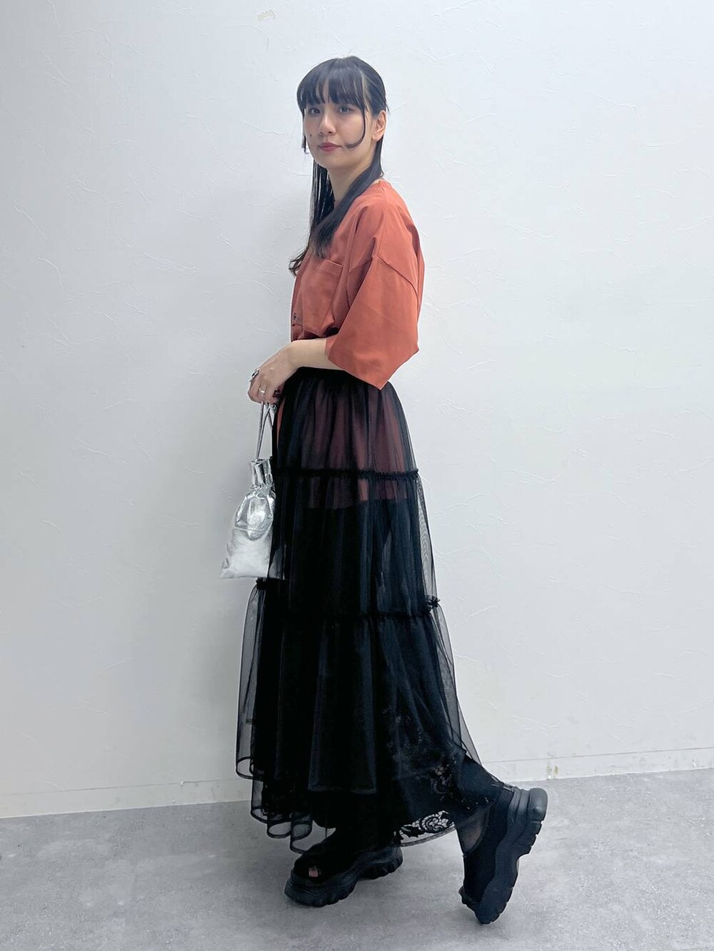 オレンジ系のTシャツ/カットソー、ブラック系のその他パンツ、ブラック系のサンダルを着用したレディースの夏コーディネートの2枚目の写真