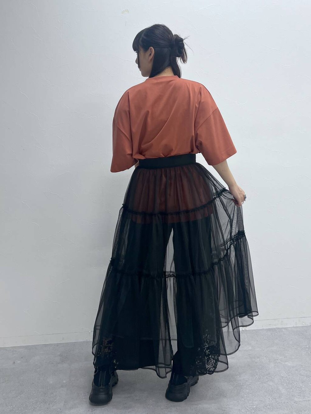 オレンジ系のTシャツ/カットソー、ブラック系のその他パンツ、ブラック系のサンダルを着用したレディースの夏コーディネートの3枚目の写真