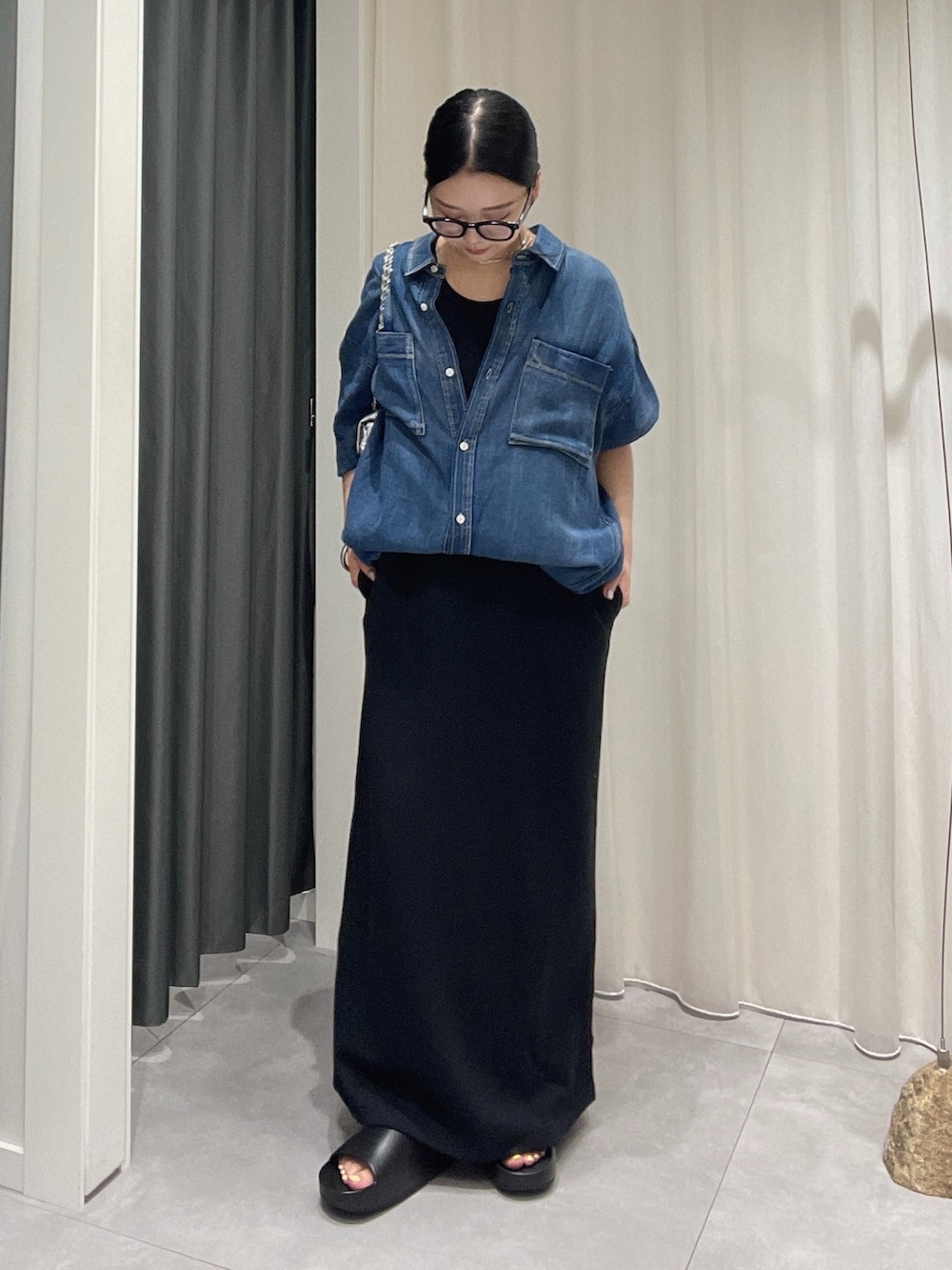 ブラック系のワンピース、シルバー系のショルダーバッグ、ブルー系のシャツ/ブラウスを着用したレディースの夏コーディネートの2枚目の写真