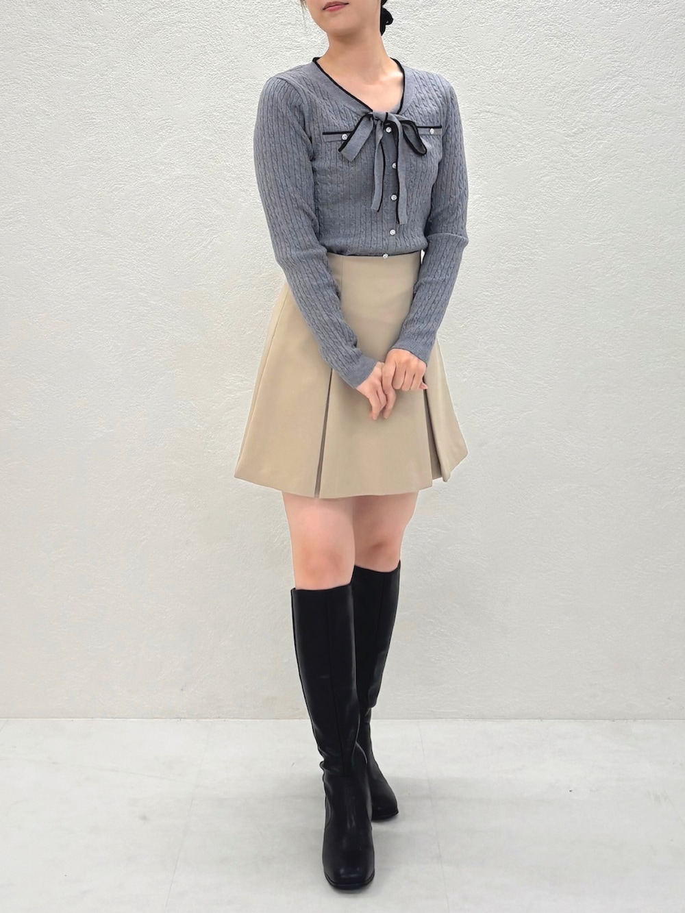 ベージュ系のスカート、グレー系のニット/セーターを着用したレディースの秋コーディネートの3枚目の写真