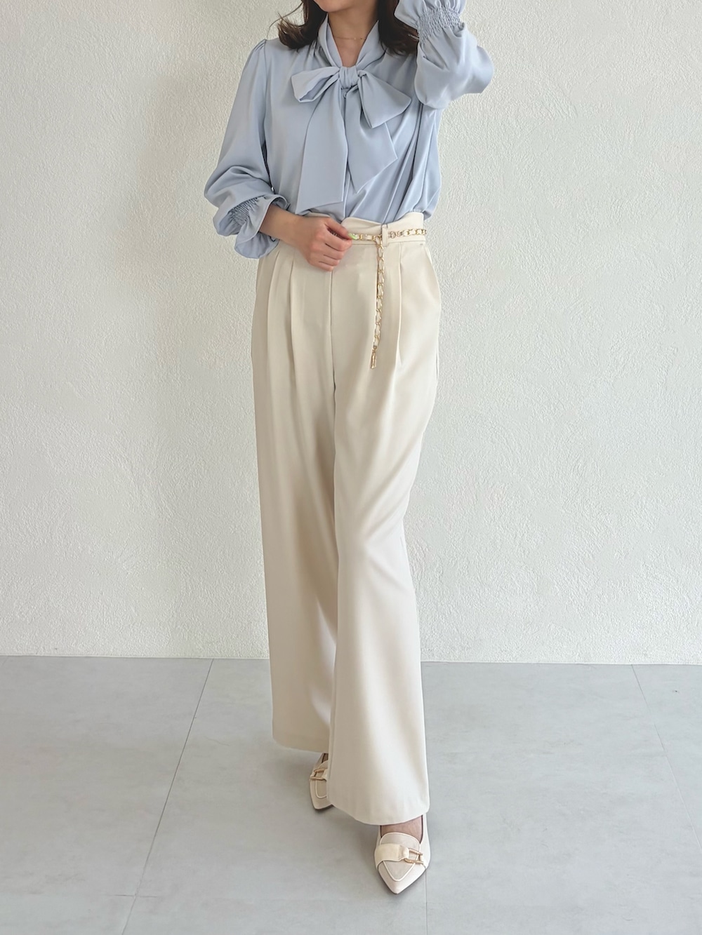 ブルー系のシャツ/ブラウス、ベージュ系のスラックスを着用したレディースの春コーディネートの2枚目の写真