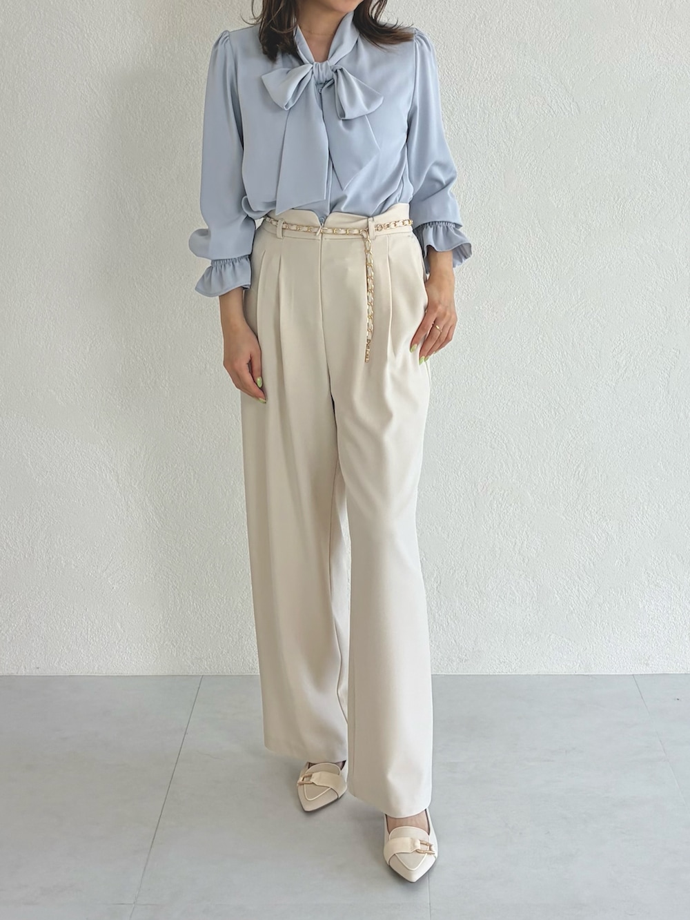 ブルー系のシャツ/ブラウス、ベージュ系のスラックスを着用したレディースの春コーディネートの3枚目の写真