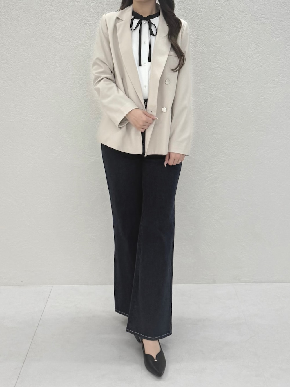 ブルー系のデニムパンツ、ホワイト系のシャツ/ブラウス、ベージュ系のテーラードジャケットを着用したレディースの春コーディネートの3枚目の写真