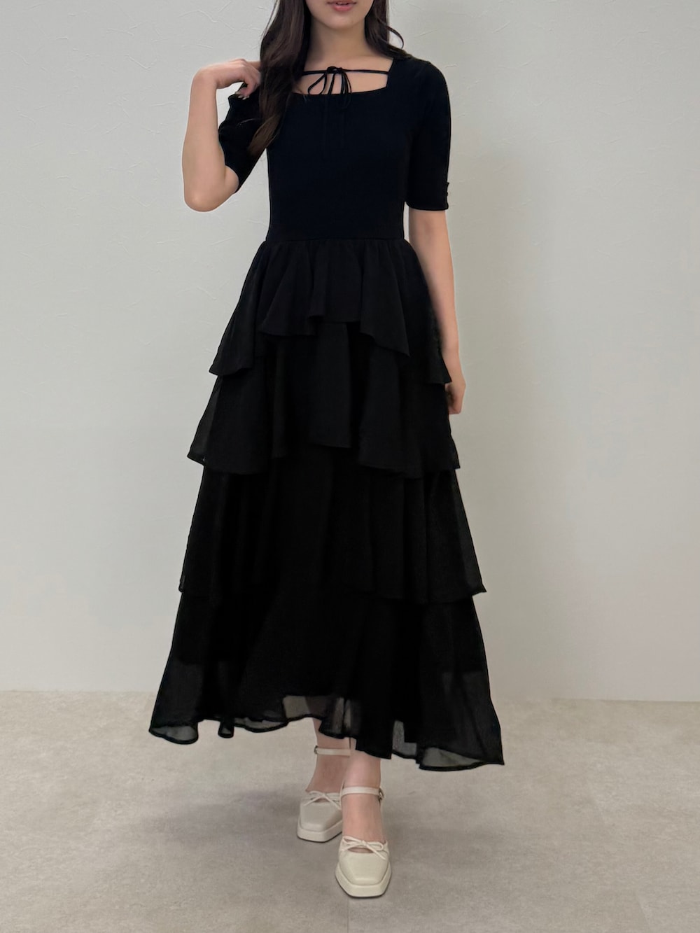 ブラック系のワンピース、ベージュ系のテーラードジャケットを着用したレディースの春コーディネートの3枚目の写真