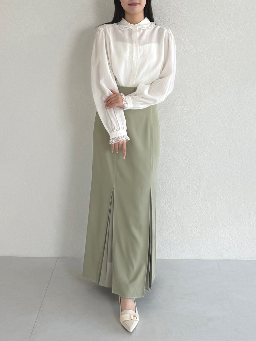 ホワイト系のシャツ/ブラウス、グリーン系のスカートを着用したレディースの春コーディネートの2枚目の写真