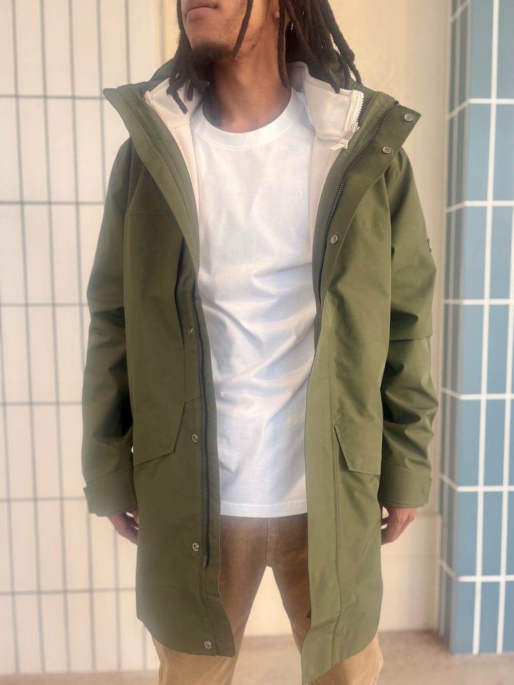 グリーン系のマウンテンパーカー、ホワイト系のその他トップス、ホワイト系のTシャツ/カットソーを着用したメンズの秋コーディネートの7枚目の写真