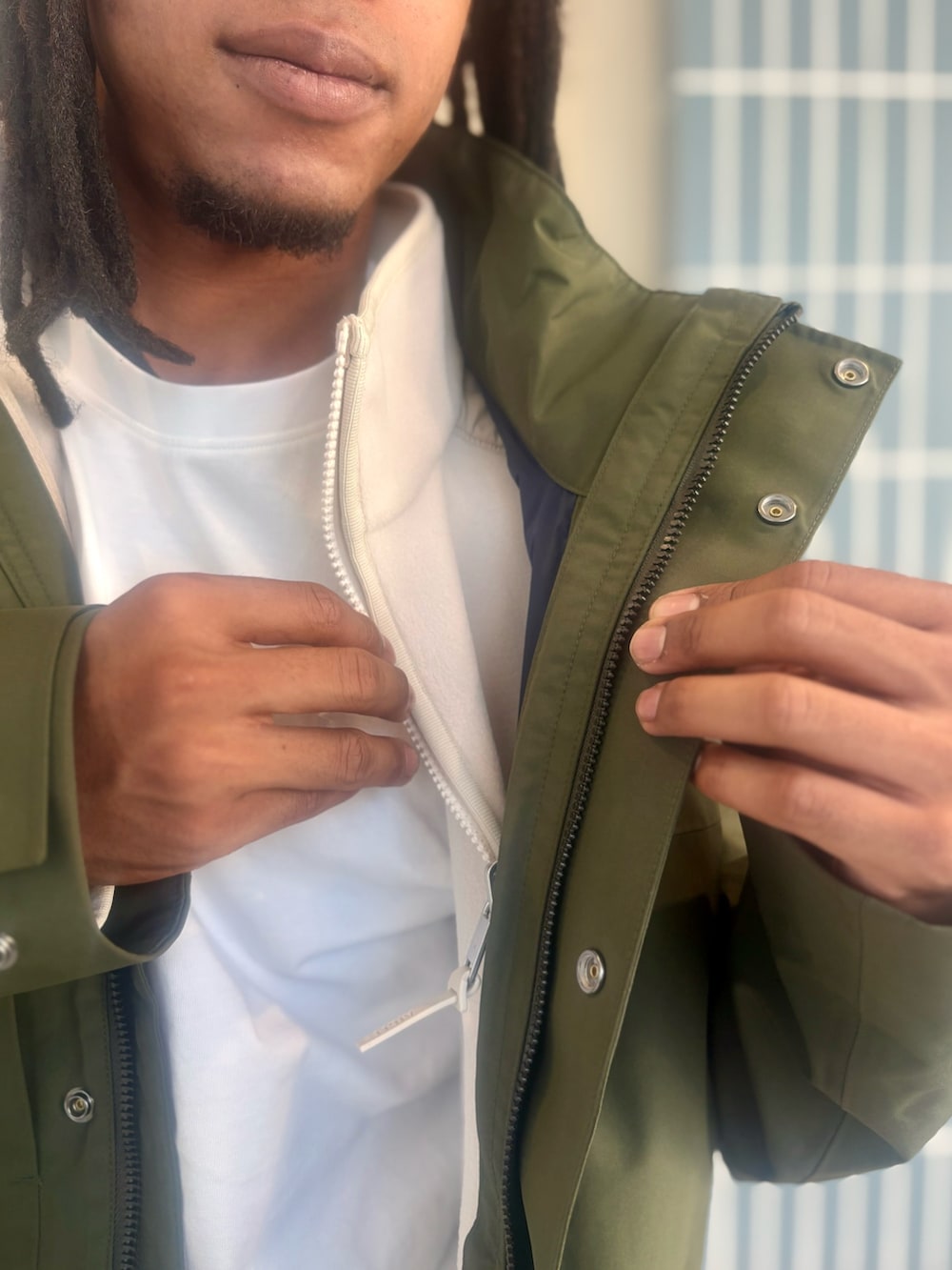 グリーン系のマウンテンパーカー、ホワイト系のその他トップス、ホワイト系のTシャツ/カットソーを着用したメンズの秋コーディネートの5枚目の写真