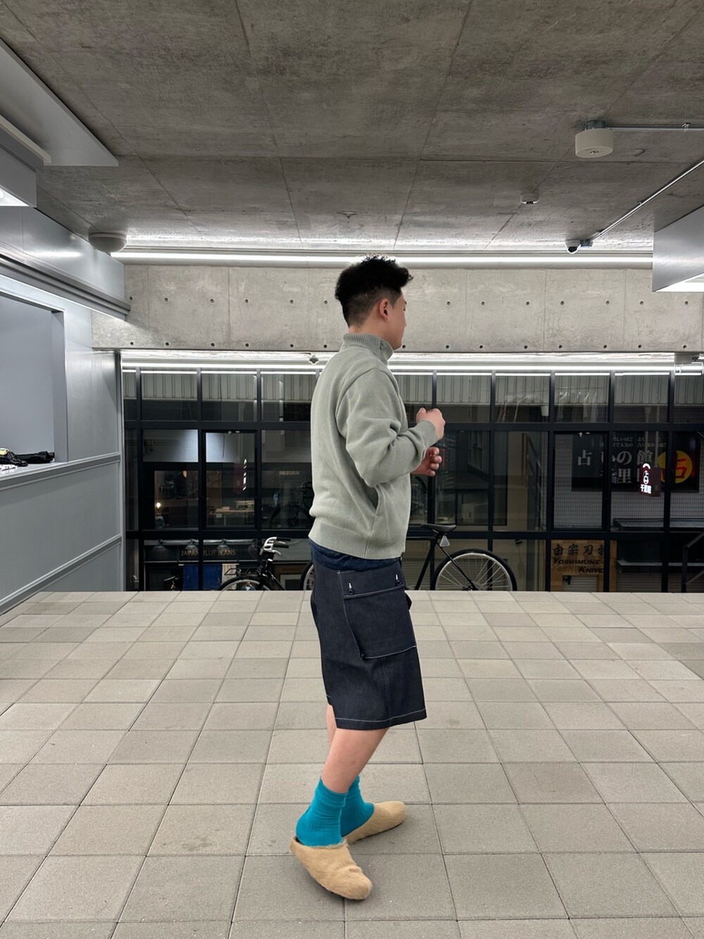 ブルー系のその他パンツ、グレー系のニット/セーターを着用したメンズの春コーディネートの3枚目の写真