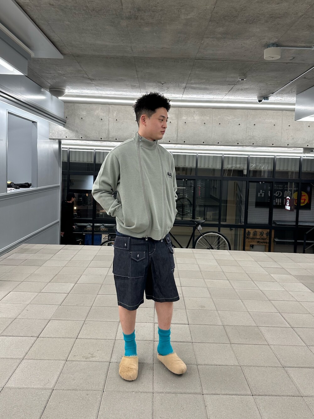 ブルー系のその他パンツ、グレー系のニット/セーターを着用したメンズの春コーディネートの2枚目の写真
