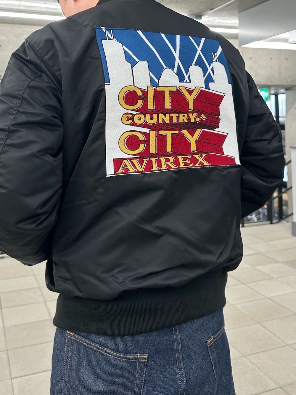 ブラック系のMA-1、ブルー系のデニムパンツを着用したメンズの冬コーディネートの3枚目の写真