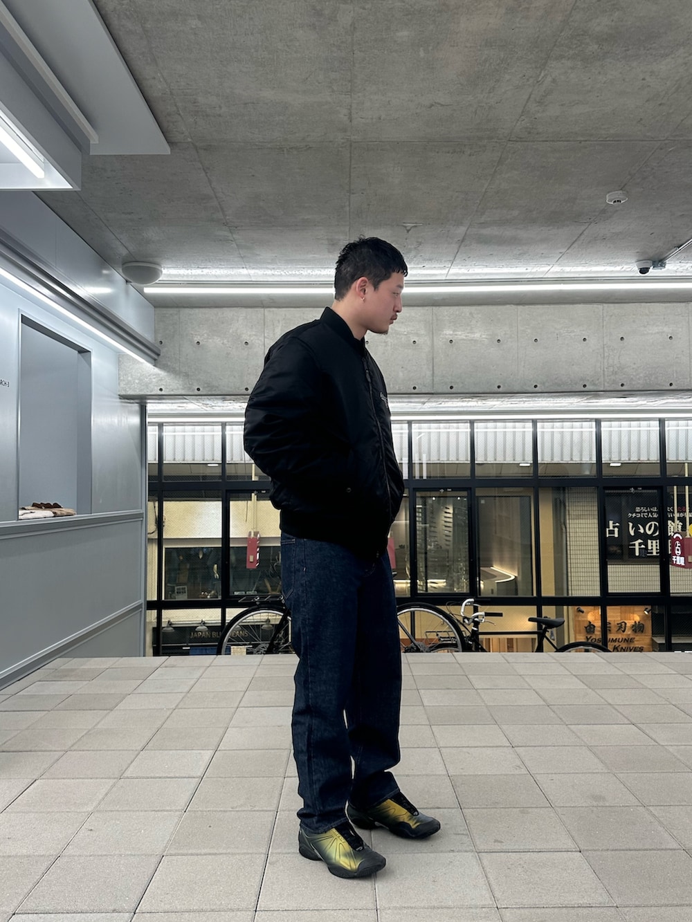 ブラック系のMA-1、ブルー系のデニムパンツを着用したメンズの冬コーディネートの2枚目の写真