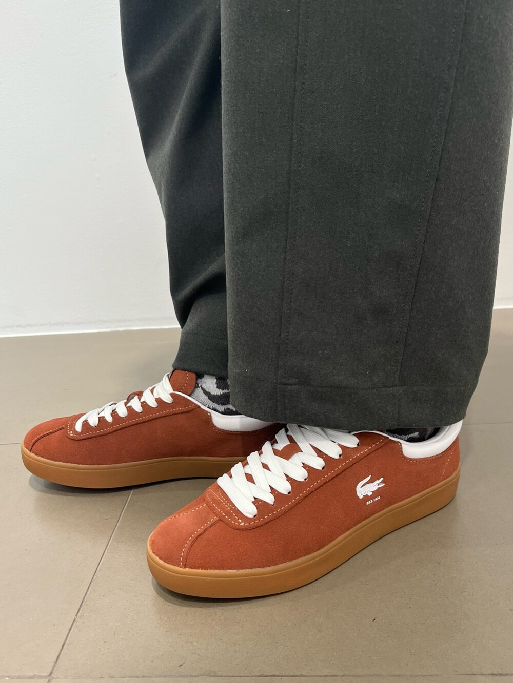 ホワイト系のチェスターコート、ブラック系のショルダーバッグ、グリーン系のその他パンツを着用したレディースの春コーディネートの5枚目の写真