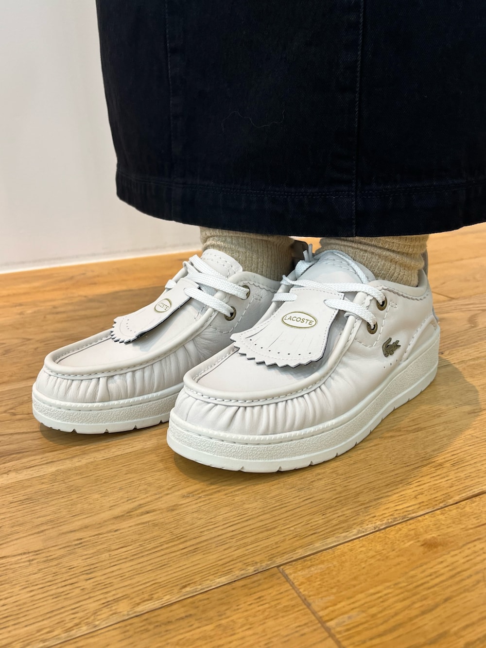 ホワイト系のTシャツ/カットソー、レッド系のポロシャツ、ホワイト系のスニーカーを着用したレディースの秋コーディネートの4枚目の写真