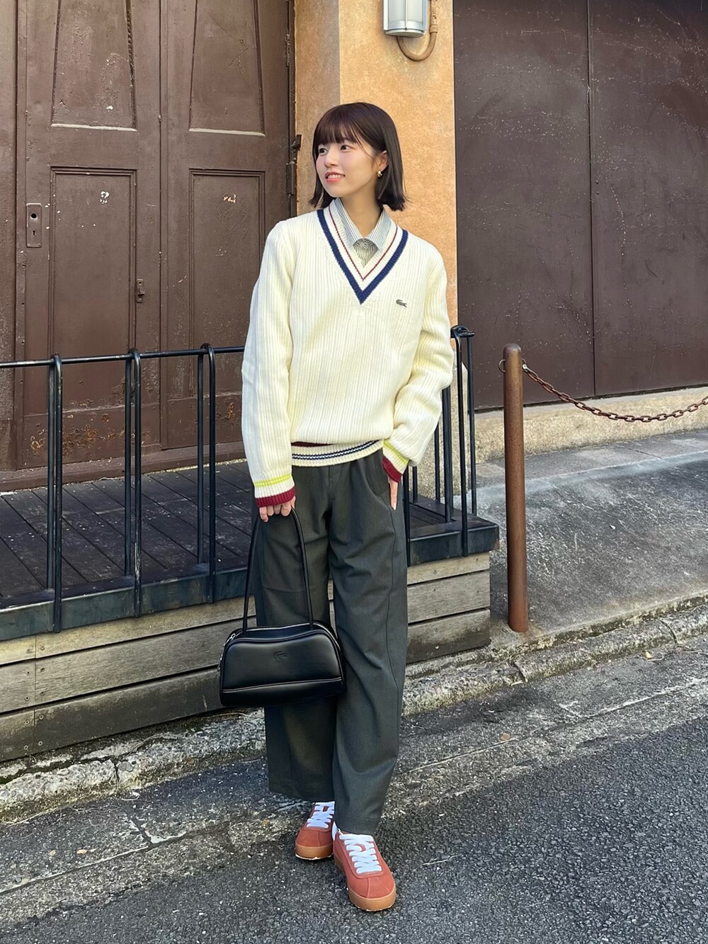 ホワイト系のチェスターコート、ブラック系のショルダーバッグ、グリーン系のその他パンツを着用したレディースの春コーディネートの2枚目の写真