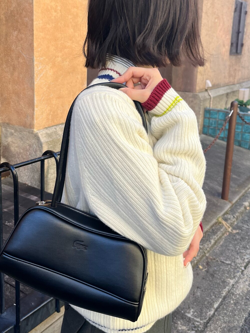 ホワイト系のチェスターコート、ブラック系のショルダーバッグ、グリーン系のその他パンツを着用したレディースの春コーディネートの3枚目の写真