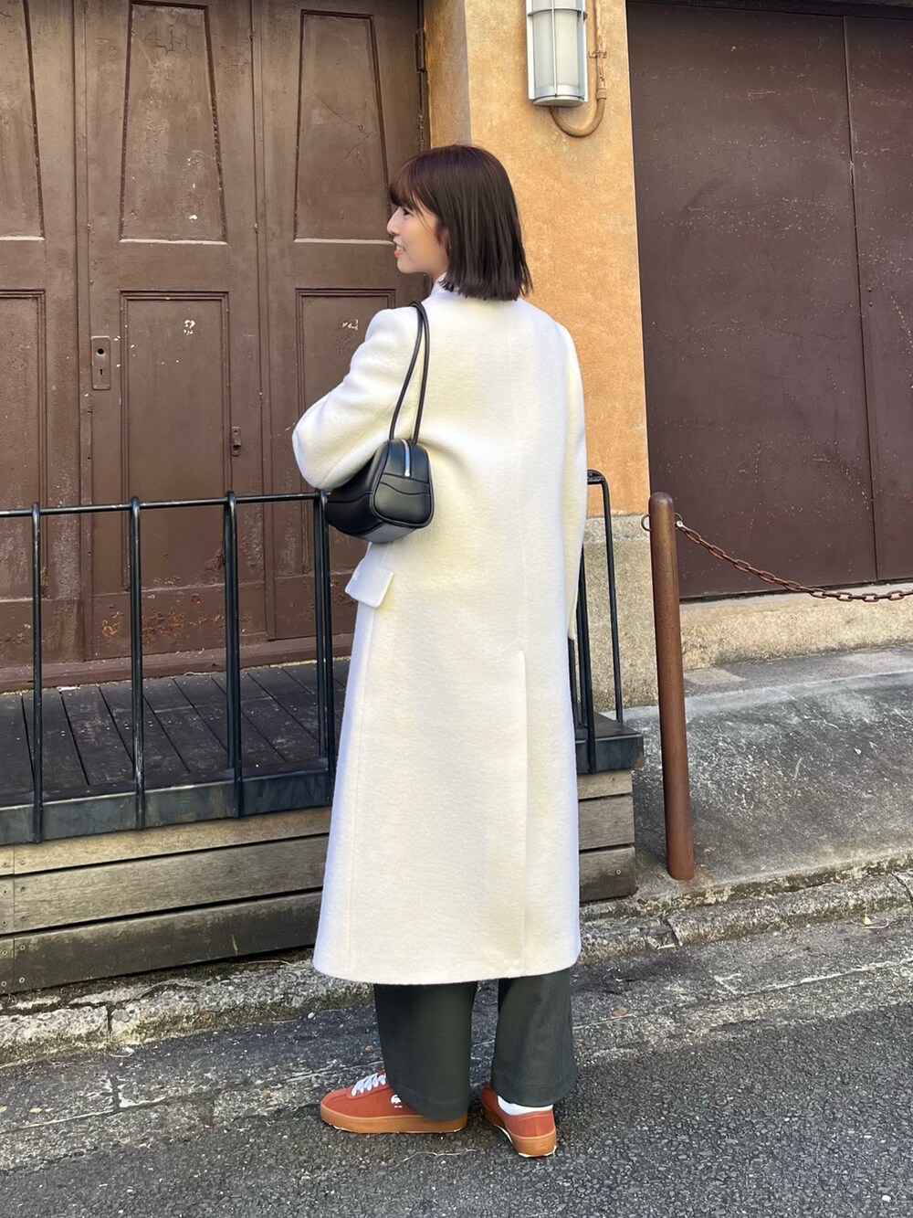 ホワイト系のチェスターコート、ブラック系のショルダーバッグ、グリーン系のその他パンツを着用したレディースの春コーディネートの7枚目の写真