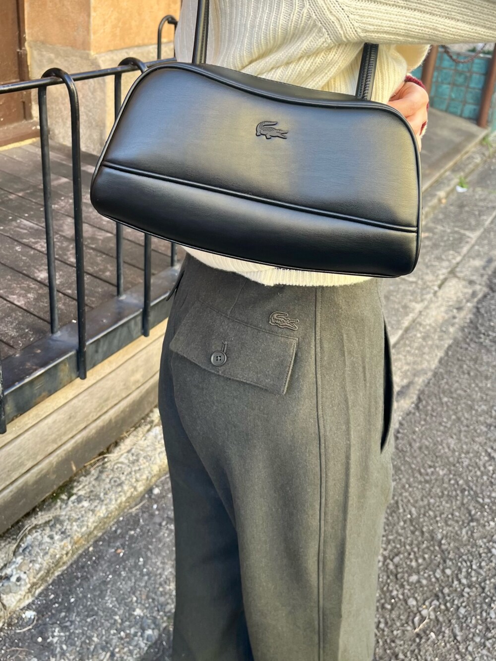 ホワイト系のチェスターコート、ブラック系のショルダーバッグ、グリーン系のその他パンツを着用したレディースの春コーディネートの6枚目の写真