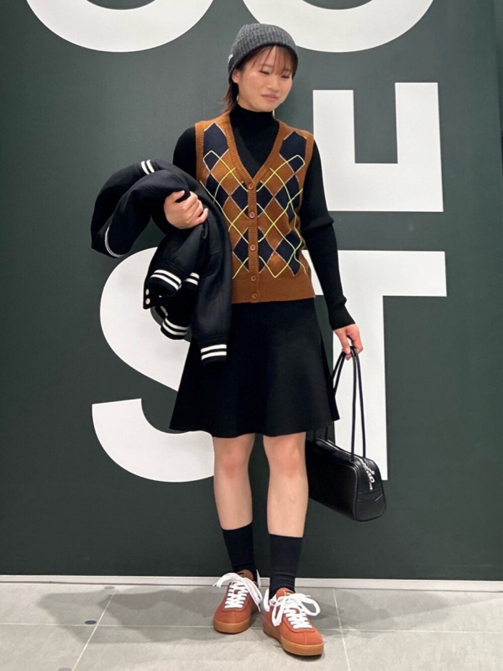 「レザーバッグ、ニットベスト、ニット帽、アウター」｜「LACOSTEのウールバーシティジャケット / 中綿ブルゾン（ブルゾン、ブラック系）」を使った、Uiさん（骨格ウェーブ・レディース・153cm）の春コーディネートの2枚目の写真