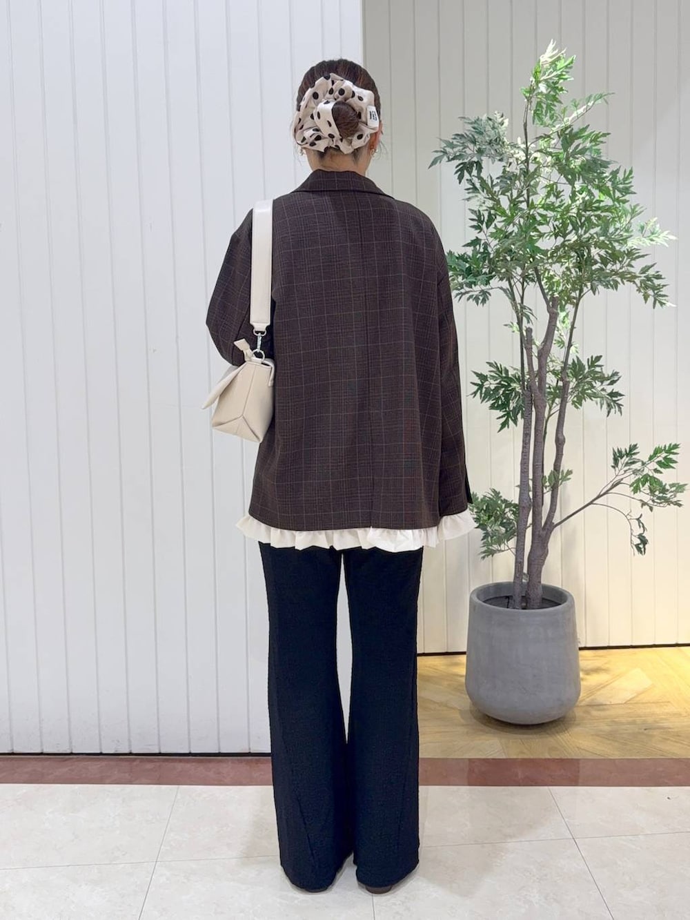 ホワイト系のショルダーバッグ、ブラウン系のブーツ、ホワイト系のTシャツ/カットソーを着用したレディースの秋コーディネートの3枚目の写真
