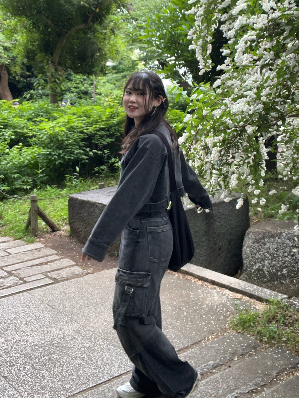 グレー系のデニムパンツ、グレー系のデニムジャケット、ブラック系のショルダーバッグを着用したレディースの春コーディネートの4枚目の写真