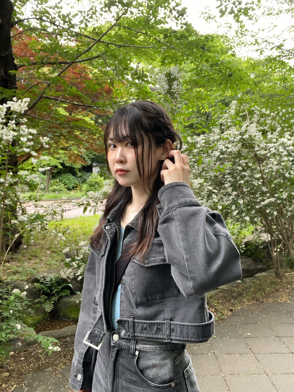 グレー系のデニムパンツ、グレー系のデニムジャケット、ブラック系のショルダーバッグを着用したレディースの春コーディネートの2枚目の写真