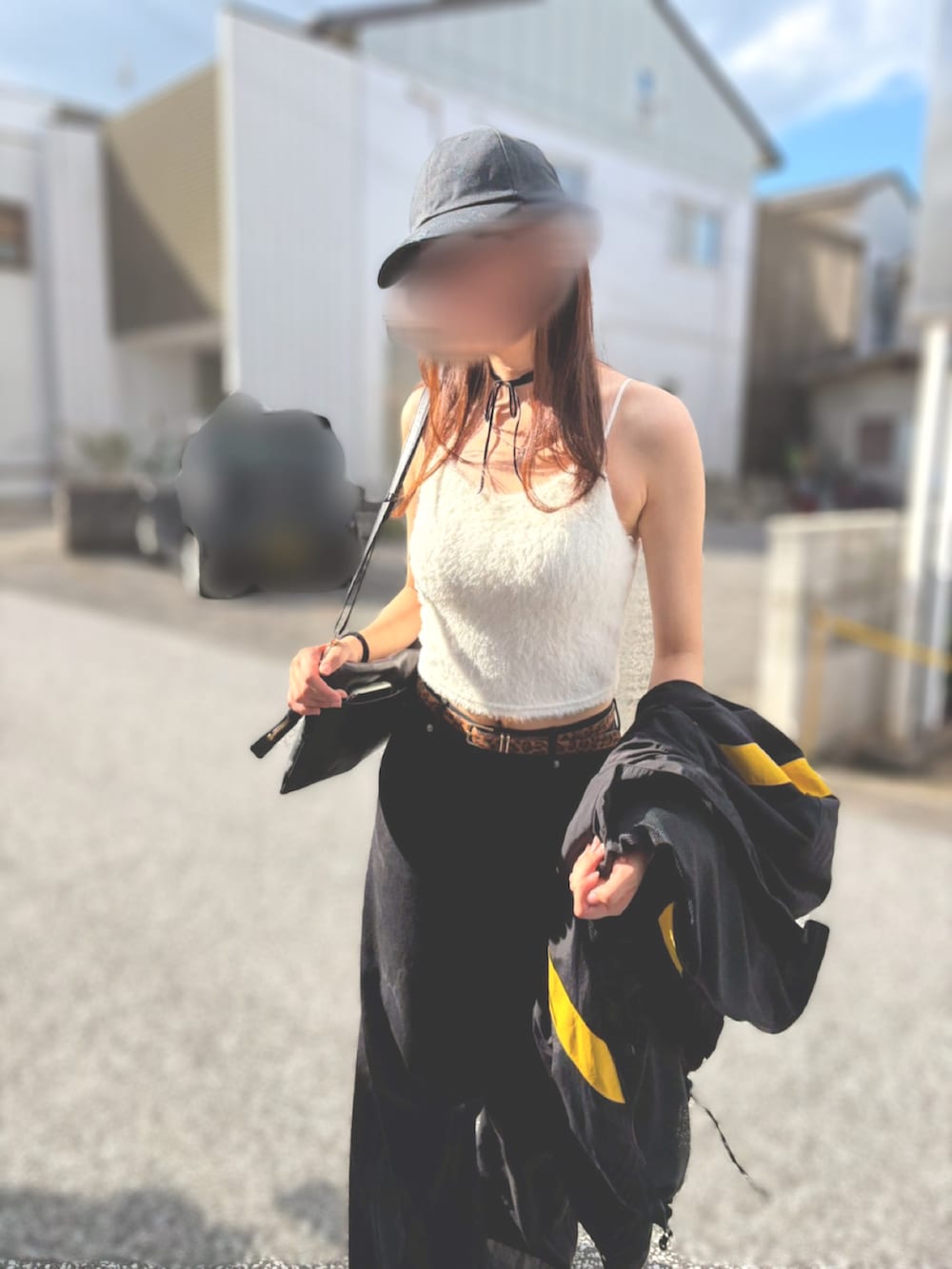 ブラック系のデニムパンツ、ホワイト系のキャミソール、ブラック系のナイロンジャケットを着用したレディースの秋コーディネートの2枚目の写真