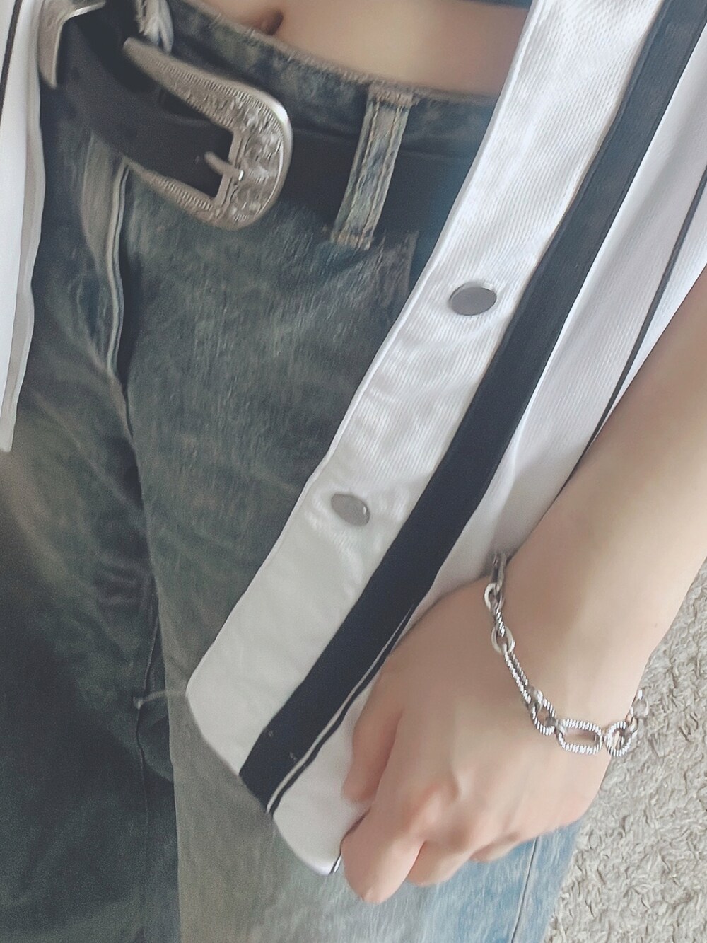 グレー系のトップス、ホワイト系のジャケット/アウター、ブルー系のデニムパンツを着用したレディースの秋コーディネートの2枚目の写真