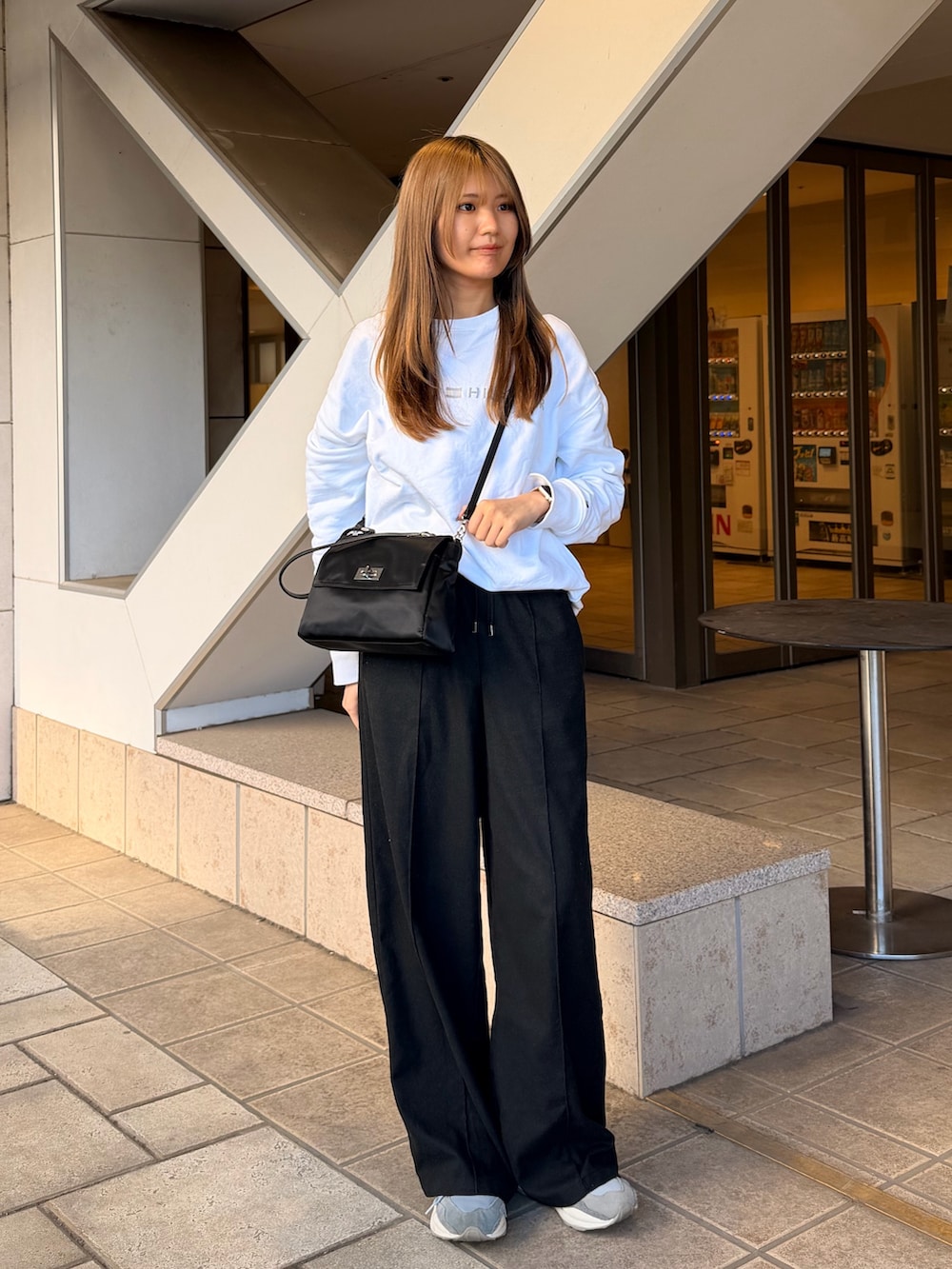 ブラック系のトートバッグを着用したレディースの冬コーディネートの2枚目の写真