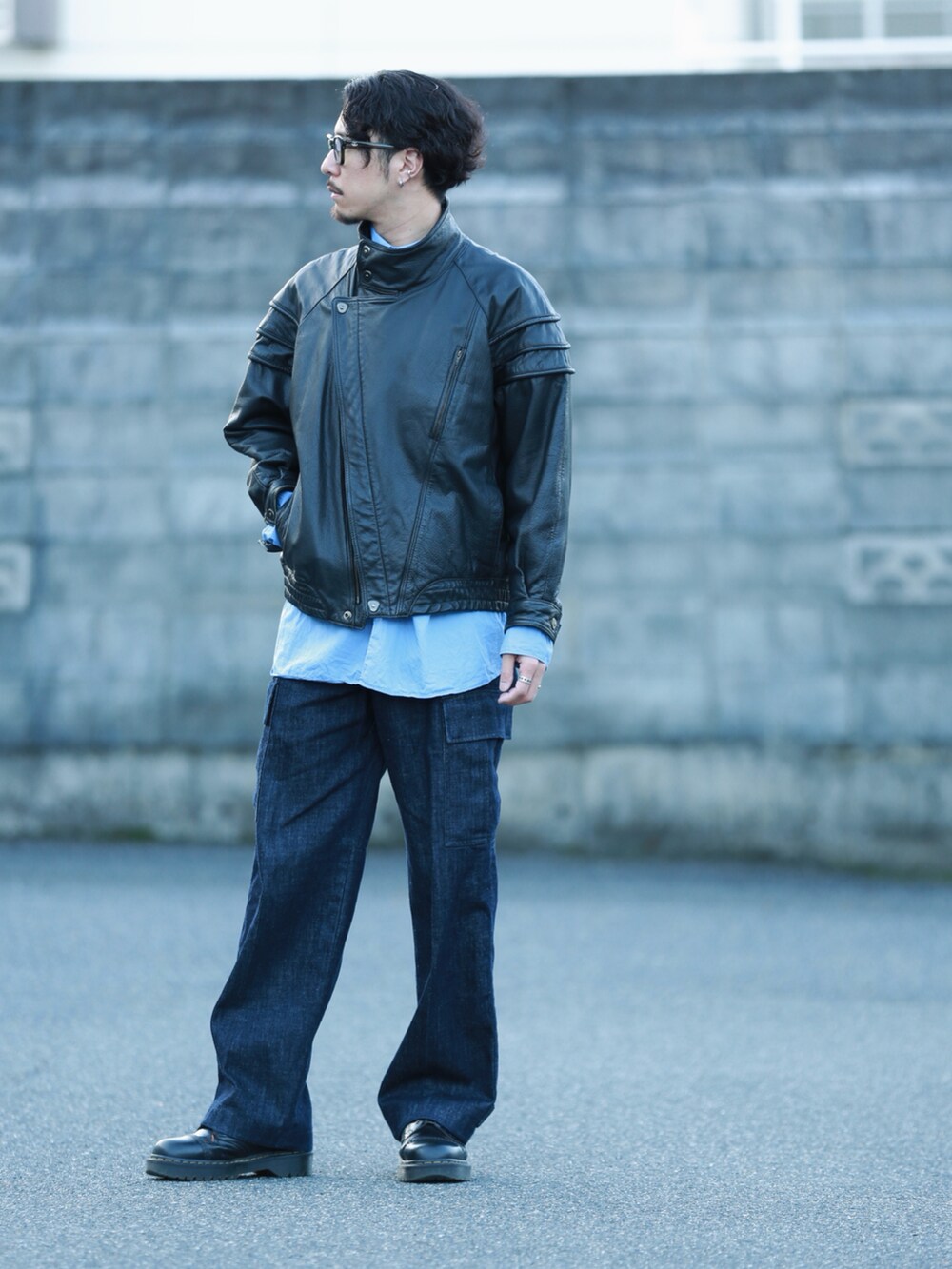 ブルー系のデニムパンツ、ブラック系のブーツを着用したメンズの秋コーディネートの2枚目の写真