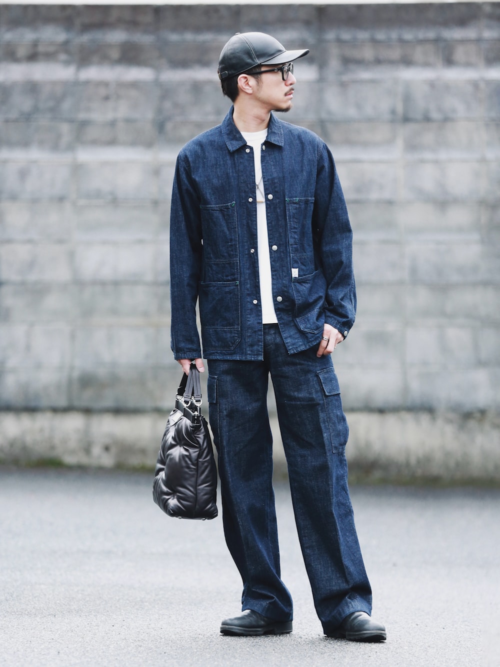 ブラック系のバッグ、ブルー系のデニムジャケット、ブルー系のデニムパンツを着用したメンズの秋コーディネートの4枚目の写真