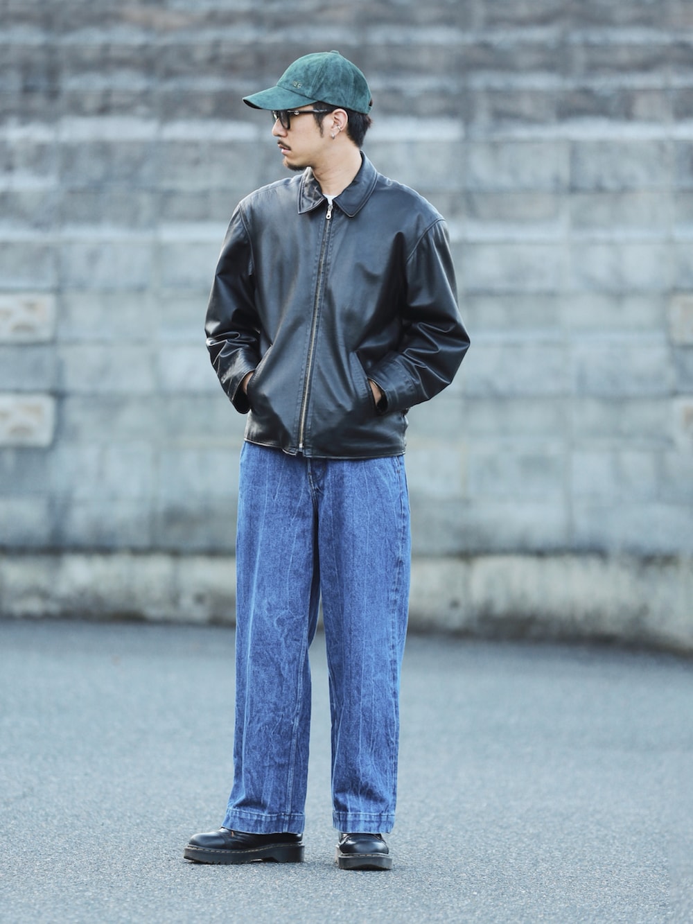 ブラック系のその他アウター、ブルー系のデニムパンツ、ブラウン系のハンドバッグを着用したメンズの秋コーディネートの2枚目の写真