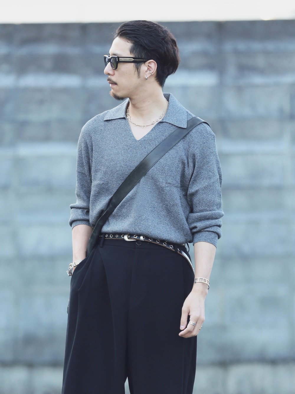 グレー系のニット/セーター、ブラック系のスラックス、グレー系のスリッポンを着用したメンズの秋コーディネートの3枚目の写真